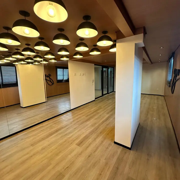 Academia com piso vinílico e iluminação pendente