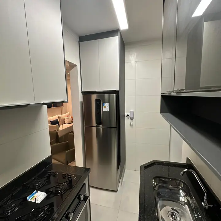 Cozinha com geladeira inox e armários